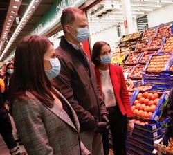 Don Felipe y Doña Letizia conversan con una empleada de un puesto de las naves de frutas y verduras