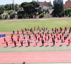 Fotografía de grupo de Sus Majestades los Reyes con una representación de nuestros atletas, en la pista de atletismo del Centro de Alto Rendimiento (C