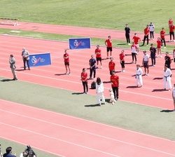 Doña Letizia junto a un atleta paralímpico y otros atletas en la pista de atletismo del Centro de Alto Rendimiento (CAR)