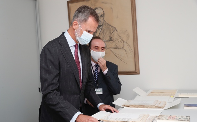 Su Majestad el Rey observa algunos manuscritos del archivo histórico