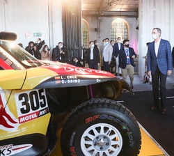 Los Reyes y sus hijas observan uno de los vehículos de rallye utilizados por Carlos Sainz