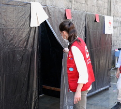 Doña Letizia en la zona de saneamientos (lavaderos y duchas) dentro del recorrido de la visita al albergue del Instituto Patria