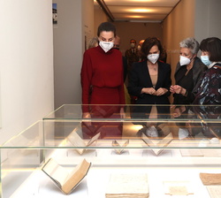 Su Majestad la Reina observa unos libros durante su recorrido por la muestra