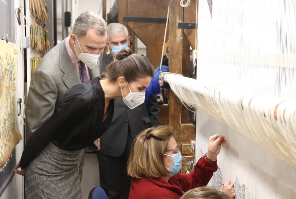 Sus Majestades los Reyes observan la fabricación de un tapiz