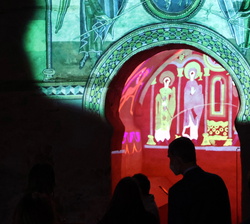 Sus Majestades los Reyes observan un video-mapeo de los frescos expoliados de la Iglesia de Santa Coloma