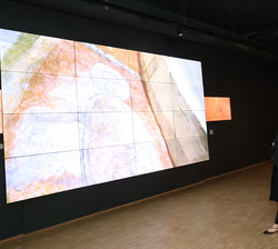 Sus Majestades los Reyes durante la proyección de un video sobre el proceso de retirada y restauración en el Espai Columba