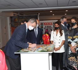 Don Felipe firma un recuerdo de la visita al Museo del Deporte