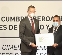 Don Felipe y el presidente del Grupo Social ONCE, Miguel Carballeda, muestran el cupón de la ONCE dedicado a la XXVII Cumbre Iberoamericana
