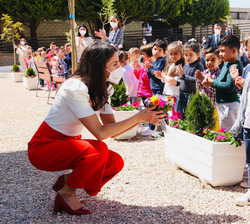 Doña Letizia conversa con uno de los alumnos que le ha ofrecido un ramo de flores