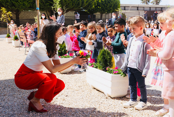 Doña Letizia conversa con uno de los alumnos que le ha ofrecido un ramo de flores