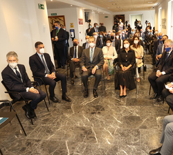 Sus Majestades los Reyes ocupan su lugar en el salón de actos