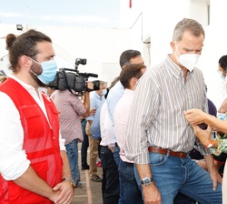 Don Felipe y Doña Letizia atienden a una vecina que les enseña como ha quedado su vivienda