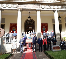 Fotografía de grupo ante una placa conmemorativa