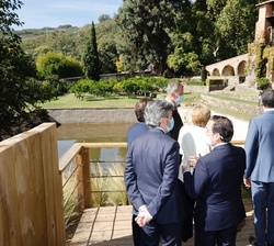 Su Majestad el Rey acompañado de las autoridades asistentes al acto con el fondo el Monasterio de Yuste