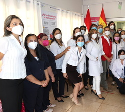 Su Majestad la Reina en la fotografía de grupo acompañada por una representación del personal del Centro de Atención Integral de Salud a la Mujer en E