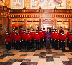 Fotografía de grupo de Su Majestad la Reina Doña Sofía con la Escolanía del Real Monasterio compuerta por 30 niños de entre 6 y 12 años