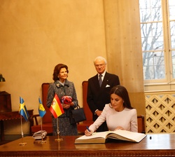 La Reina firma en el libro de honor