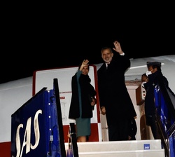 Sus Majestades los Reyes se despiden desde la escalerilla del avión real momentos antes de emprender el regreso a España
