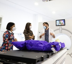 Su Majestad la Reina junto a la ministra de Sanidad atienden a las explicaciones del coordinador de técnicos de Radioterapia