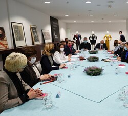 Su Majestad la Reina junto a los asistentes a la reunión previa a su visita por los stands