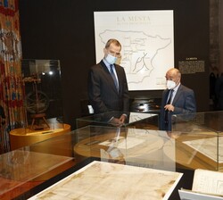 Don Felipe ante una de las obras expuestas y mapas históricos