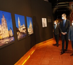 Su Majestad el Rey contempla unas fotografías expuestas