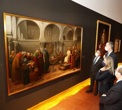 Su Majestad el Rey ante uno de los cuadros expuestos junto a las autoridades