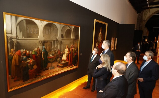 Su Majestad el Rey ante uno de los cuadros expuestos junto a las autoridades