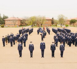Fotografía de grupo de Su Majestad el Rey junto a autoridades, personal y alumnos de la EMACOT