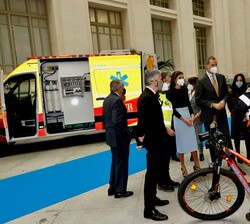 Sus Majestades los Reyes conversan con trabajadores de SAMUR-Protección Civil que les explican el uso de bicicletas en su labor
