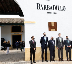 Su Majestad el Rey junto a las autoridades y la placa conmemorativa de su visita a las Bodegas Barbadillo