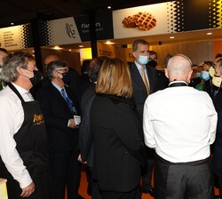 Su Majestad el Rey conversa con unos de los participantes al Salón
