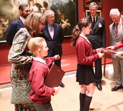Dos escolares entregan a Doña Letizia y al Príncipe de Gales la edición especial del catálogo de la Spanish Gallery