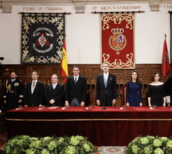 Sus Majestades los Reyes en la mesa presidencial durante la interpretación del Himno Nacional a cargo de la Orquesta "Ciudad de Alcalá"
