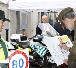 El Rey firma en uno de los expositores durante la visita