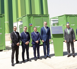 Fotografía de grupo de Su Majestad el Rey ante una Placa Conmemorativa de la inauguración, junto a las autoridades y personalidades