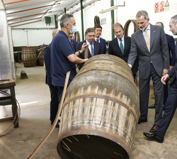 Su Majestad el Rey observa la reparación de un tonel durante su visita a la tonelería