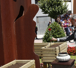 Su Majestad el Rey deposita una rosa en un macetero situado junto a la escultura "Homenaje a las víctimas del terrorismo"