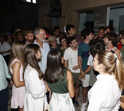 Sus Majestades los Reyes y Sus Altezas Reales la Princesa de Asturias y la Infanta Doña Sofía conversan con unos jóvenes durante su recorrido por las 