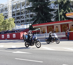 Sus Majestades los Reyes y Su Alteza Real la Infanta Doña Sofía al paso de dos motocicletas de la Policía Nacional