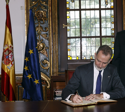 Su Majestad el Rey durante la firma en el libro de Honor