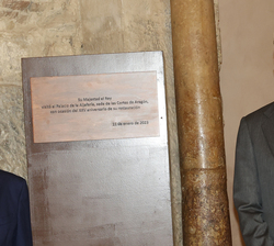 Su Majestad el Rey junto a una placa conmemorativa de la visita
