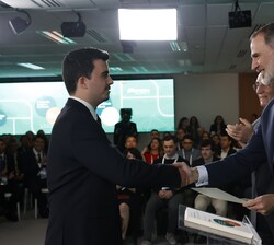 Su Majestad el Rey hace entrega del título a uno de los becados