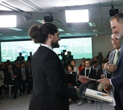 Su Majestad el Rey hace entrega del título a uno de los becados