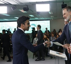 Su Majestad el Rey hace entrega del título a uno de los becados