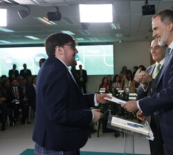 Su Majestad el Rey hace entrega del título a uno de los becados