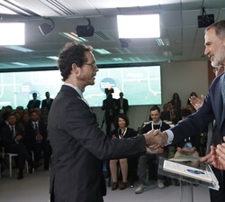 Su Majestad el Rey hace entrega del título a uno de los becados