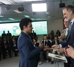 Su Majestad el Rey hace entrega del título a uno de los becados