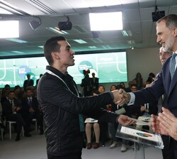 Su Majestad el Rey hace entrega del título a uno de los becados