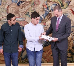 Uno de los integrantes de la primera promoción del Proyecto de formación dual “Juan María by lolola” hace entrega de un obsequio a Su Maje